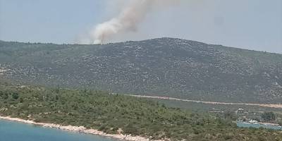 İzmir Karaburun'da makilik alanda çıkan yangına müdahale ediliyor