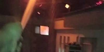 Karşı apartmandaki yangına, balkondan hortumla müdahale etti