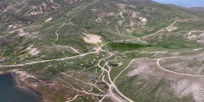 Kavurucu sıcaktan bunalıp geldikleri Erciyes'te sobayla ısınıyorlar